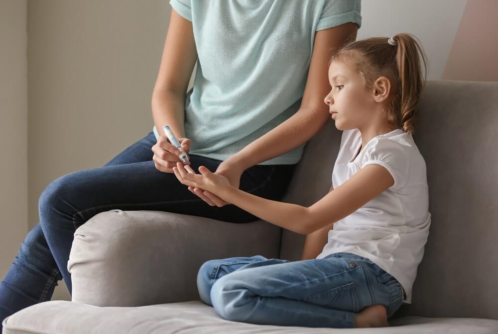 Mutter misst Tochter mit Diabetes Typ 1 den Blutzucker