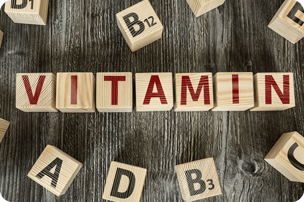 Scrabble Buchstaben mit dem Wort Vitamin und A, B, D, C Steinchen drumherum
